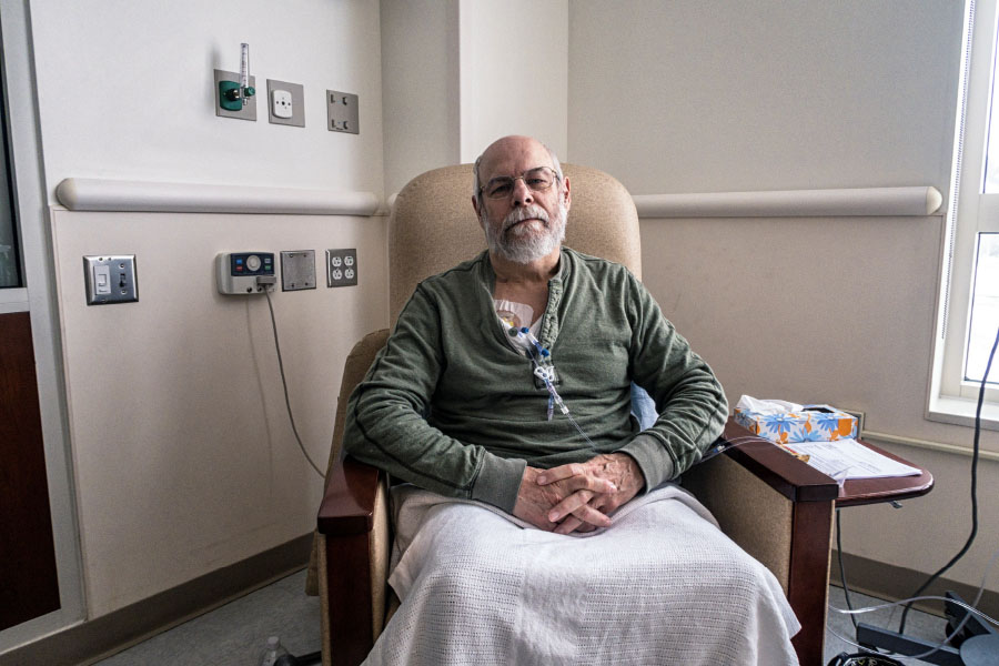 Isolated older Black male patient sitting in a chair with a blanket on his lap