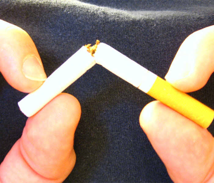 Smoker breaks cigarette in half