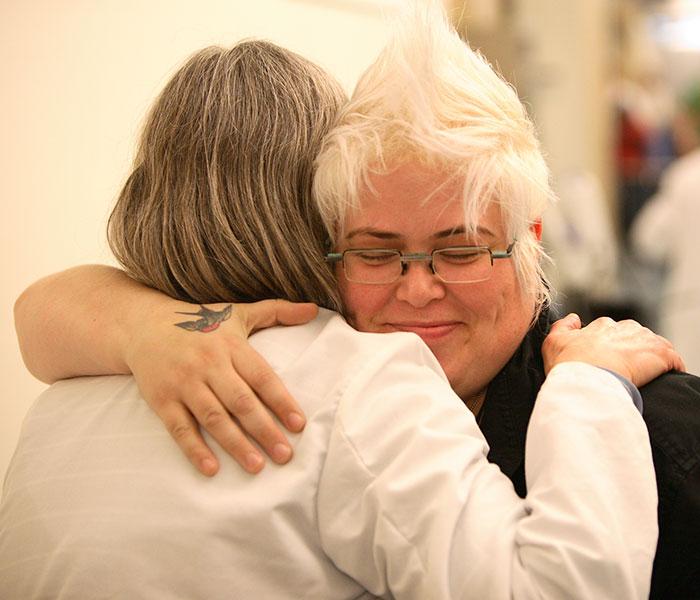 An onoclogy patient and her caregiver share a hug