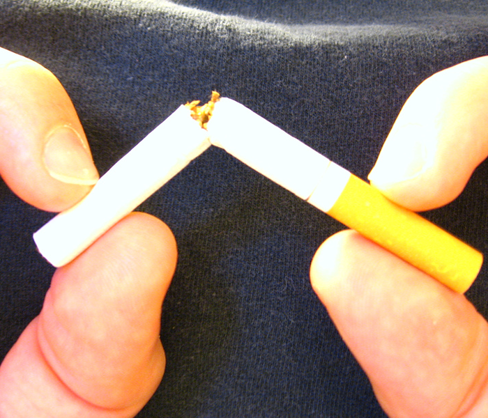 smoker breaking a cigarette in half