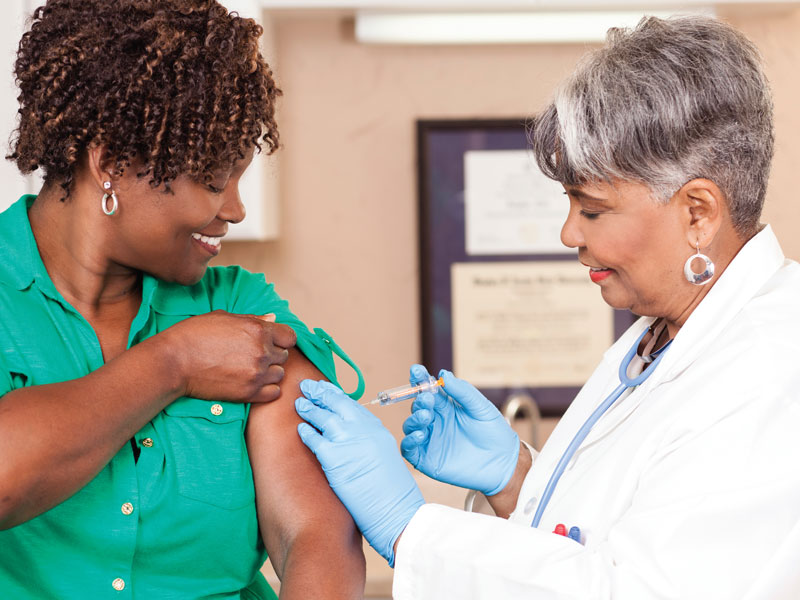 black female patient getting a vaccine from a black nurse
