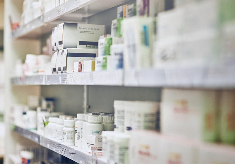 pharmacy shelves lined with prescription drugs and medications