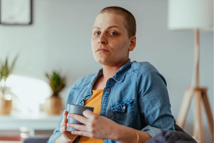 LGBTQ adolescent and young adult cancer survivor holding a mug