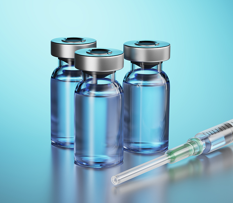 three vials and a syringe on a glowing blue background
