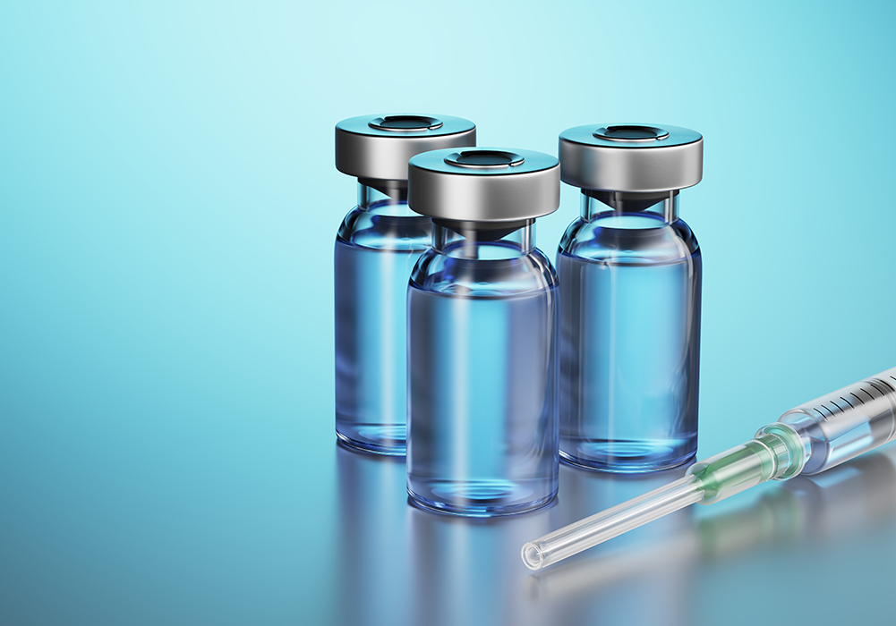 three vials and a syringe on a glowing blue background