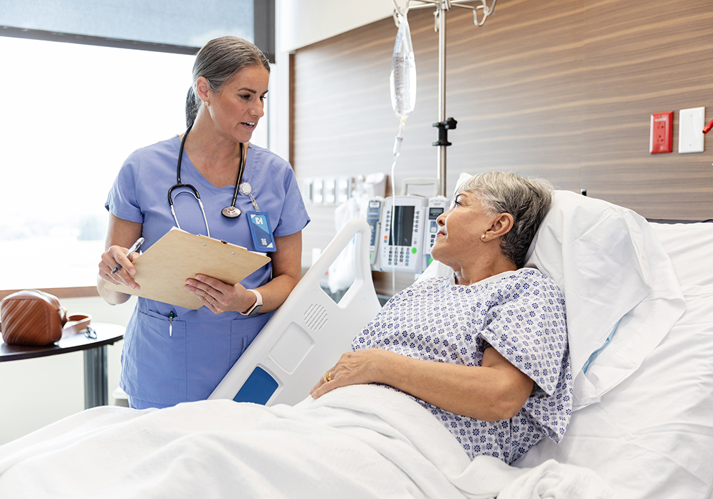 nurse talking with a patient in hospital bed