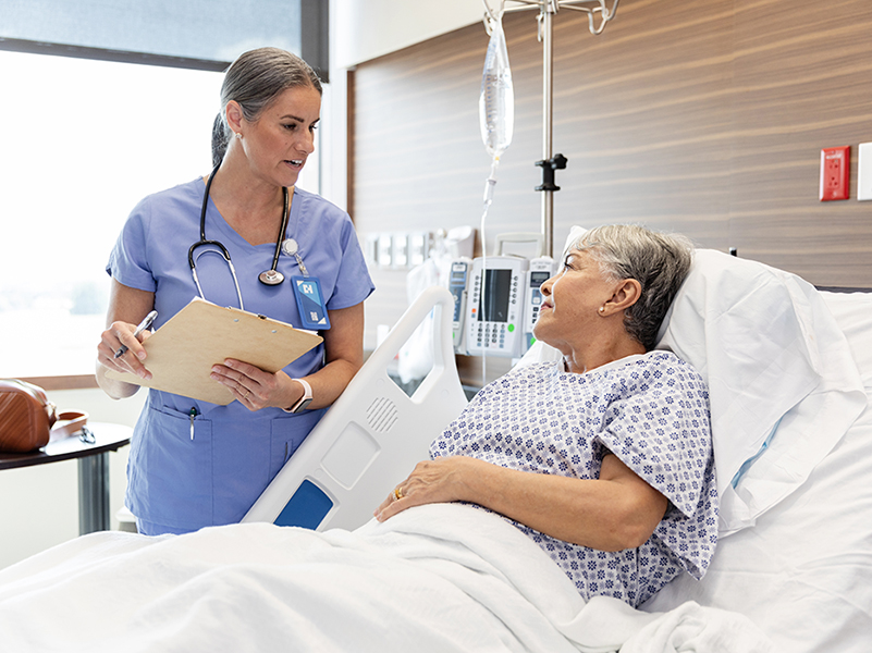 nurse talking with a patient in hospital bed