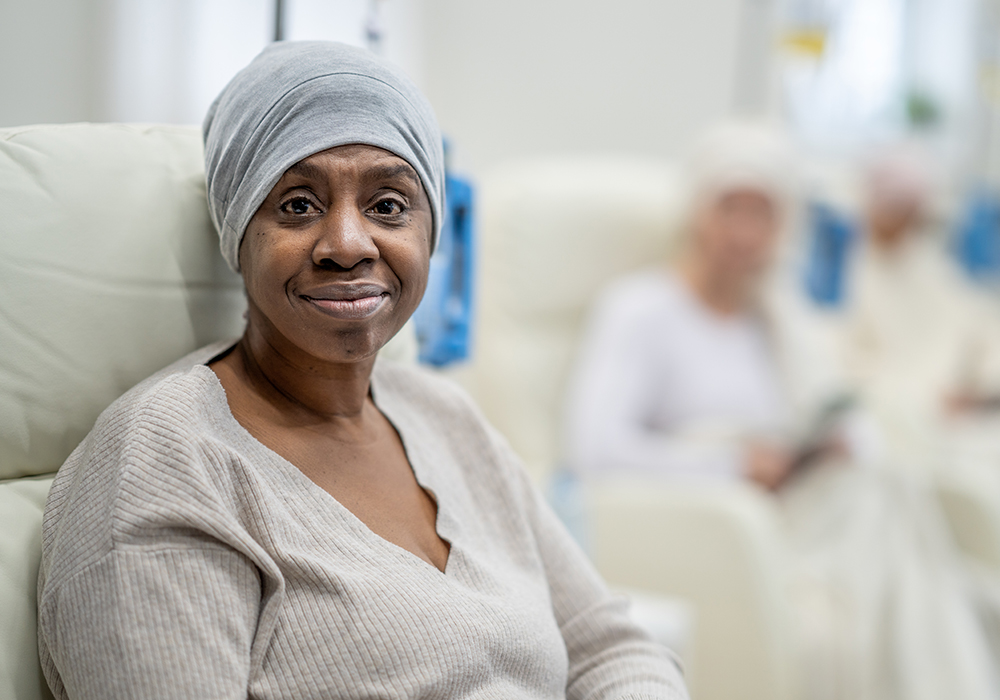 Black woman wearing hair wrap sitting in an infusion chair