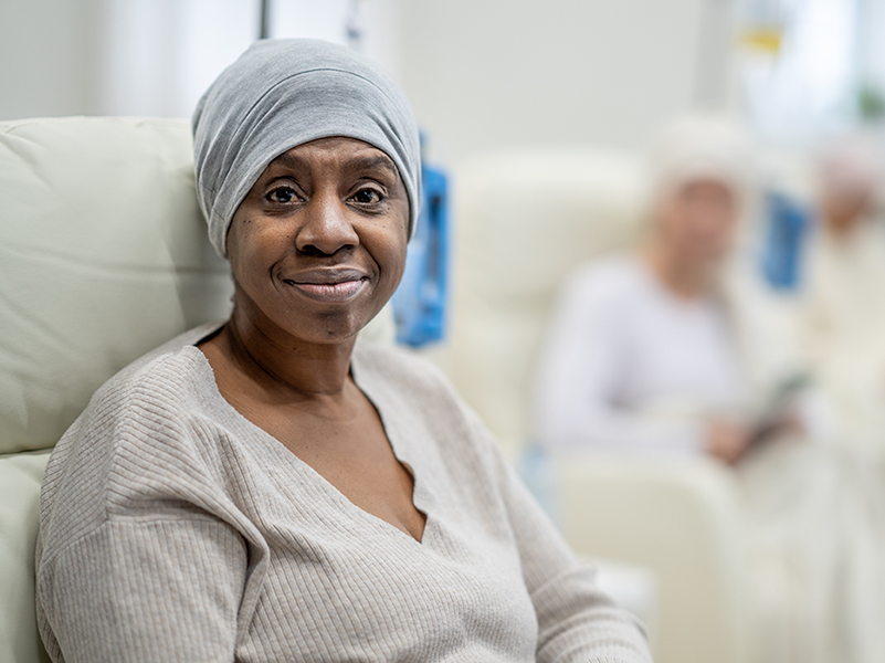 Black woman wearing hair wrap sitting in an infusion chair