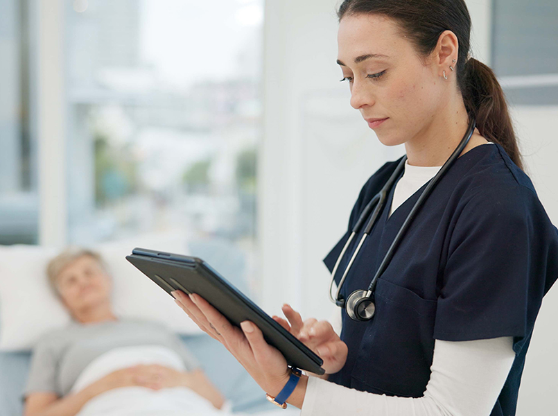 woman holding pad with patient in background