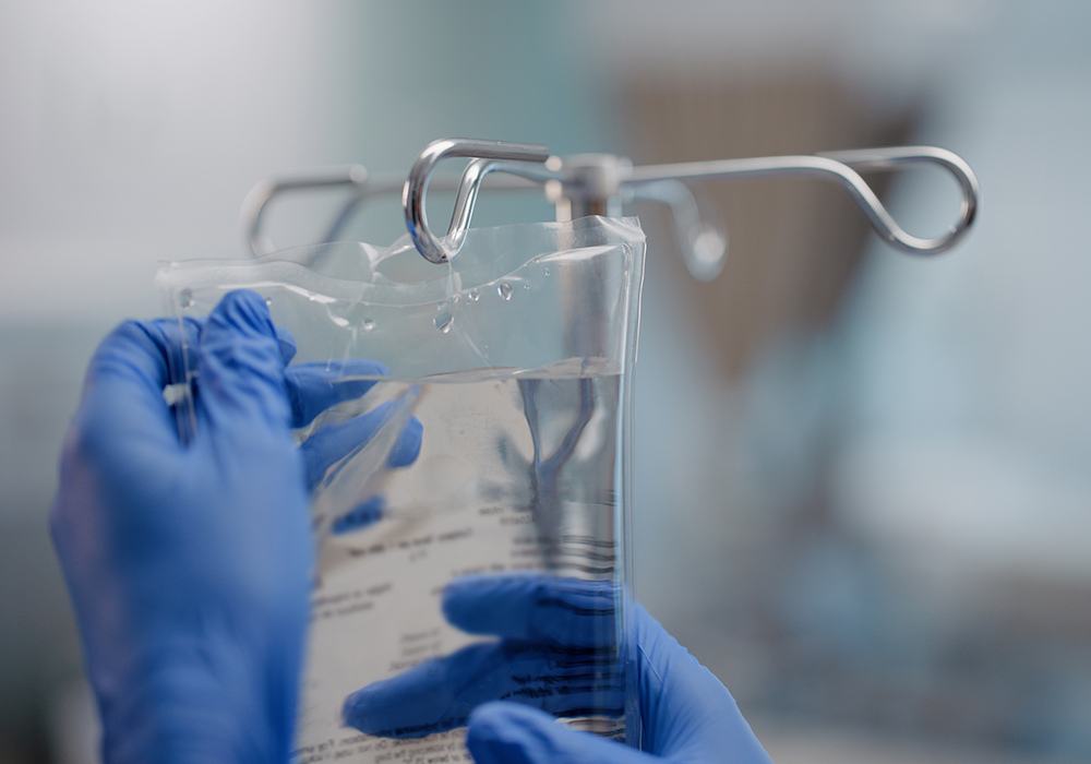 IV bag handled by gloved hands