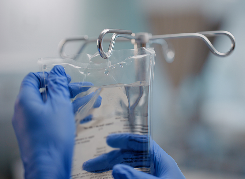 IV bag handled by gloved hands